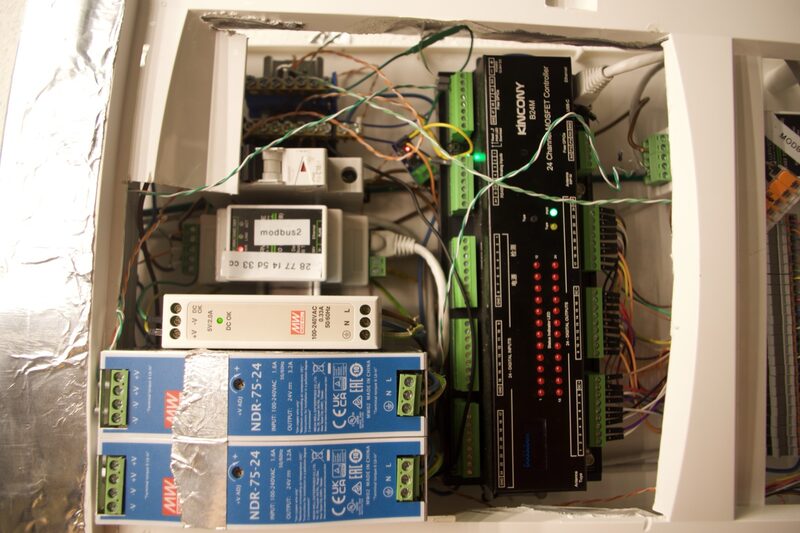 Open control cabinet with a relay controller, Modbus gateway, power supplies, and wiring